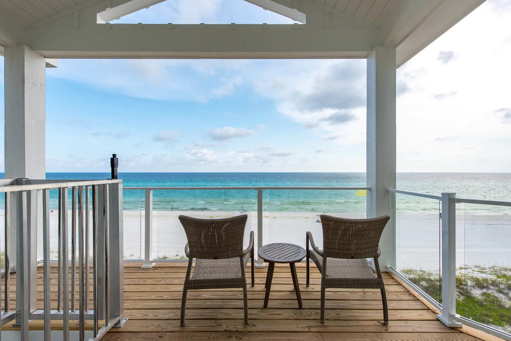 Two chairs and a table on an outdoor deck facing the ocean