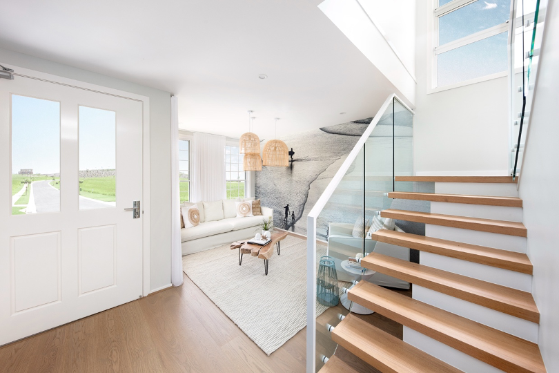 Natural light flooding into the front door, living spaces and stairwell  of pristine beach home