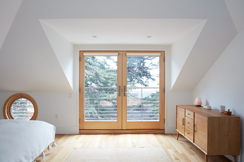 upper level sleeping loft with balcony doors and ocular window