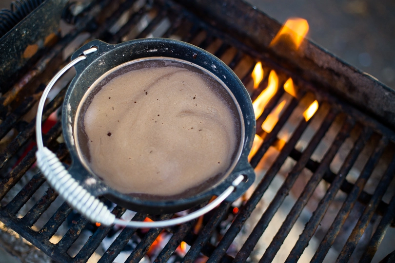 Spiced & Spiked Mexican Hot Chocolate in a pot over a campfire