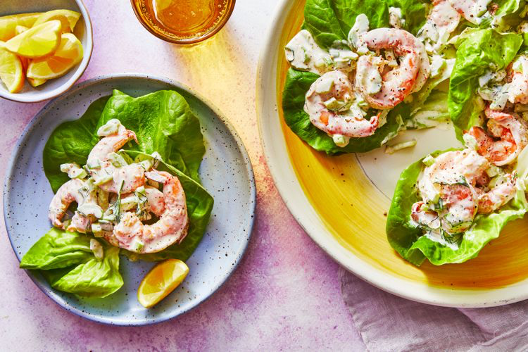 shrimp salad on plates over bibb lettuce with lemon wedges