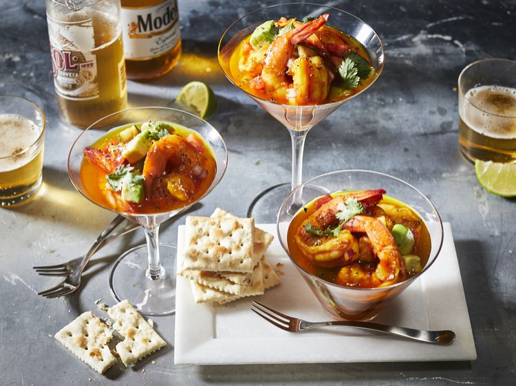 Mexican Shrimp cocktail in stemware and a coup with saltines, and Mexican beers, lime wedges