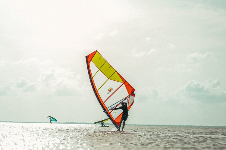 Windsurfers in Corpus Christi, Texas on the sparkling waters in the fall with the shoreline faintly in the backdrop.