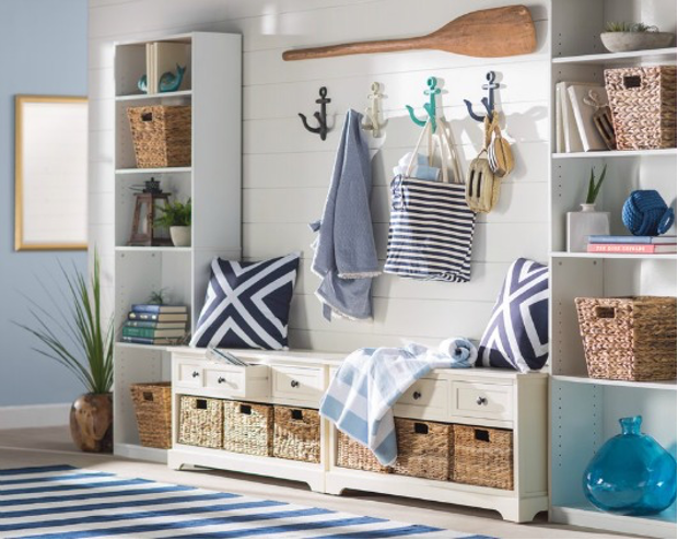 beach home entrance with built-in bench with storage, open shelving, hooks for bags and towels, mirror, striped area rug