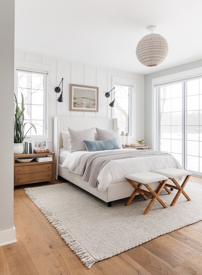 Neutral coastal-style small bedroom with under the bed storage, sconce lighting, benches, and night stand storage