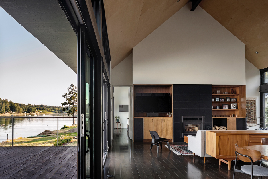 Main living area with fireplace wall sliding door transition to an outdoor deck that over looks the water and mountains of Puget Sound