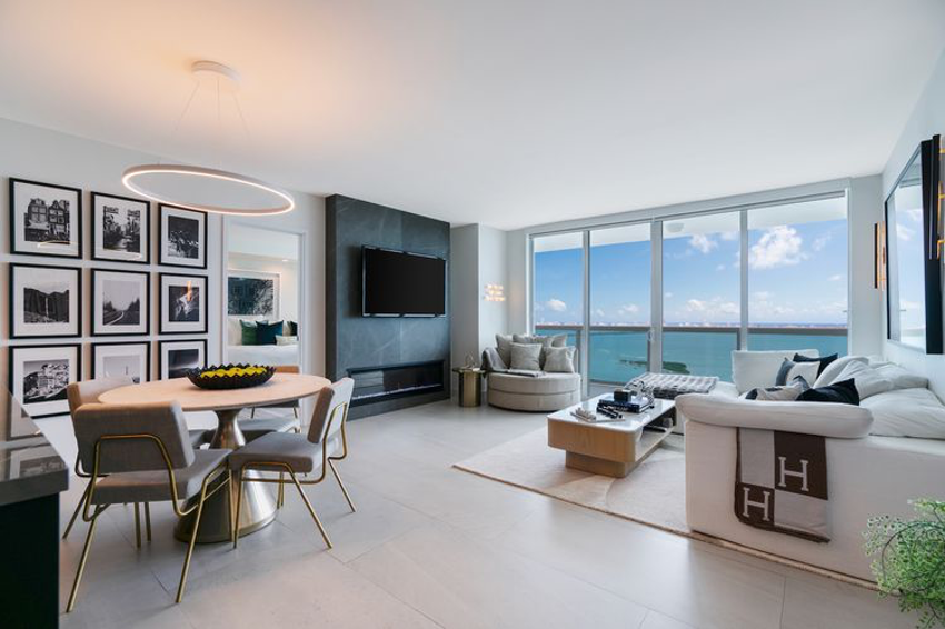 Multi-functional space demonstrated in this coastal home with open floorplan design and large expanse of sliding glass doors, living and dining areas connect visually and dining table doubles as a workspace.